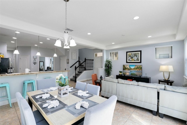 dining space with light tile patterned floors and a chandelier