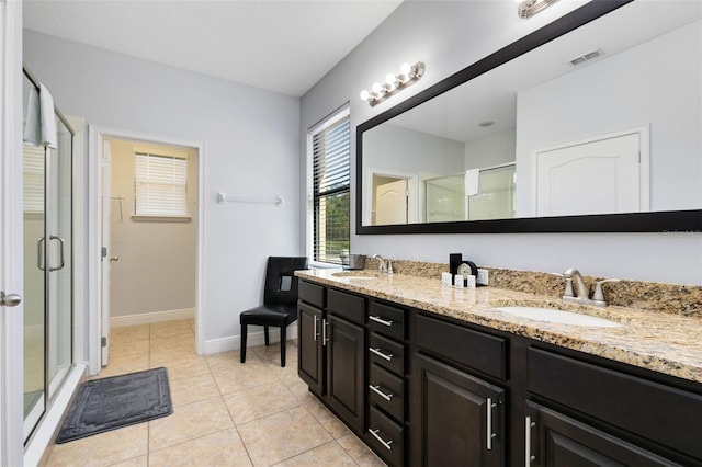 bathroom with vanity, tile patterned floors, and a shower with door