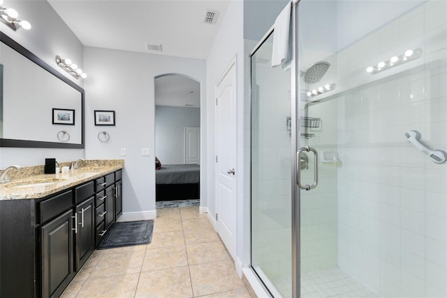 bathroom featuring tile patterned flooring, vanity, and a shower with door