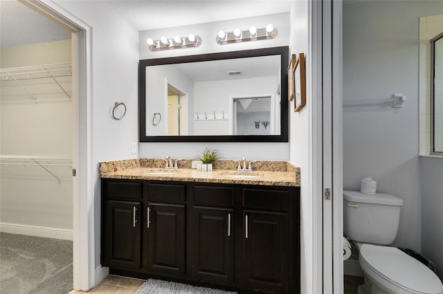 bathroom with vanity, a textured ceiling, and toilet