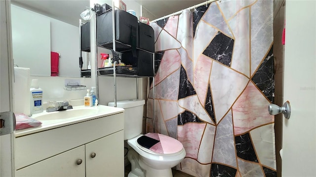 bathroom featuring toilet and vanity with extensive cabinet space