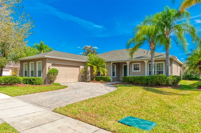 single story home with a garage, a front lawn, decorative driveway, and stucco siding