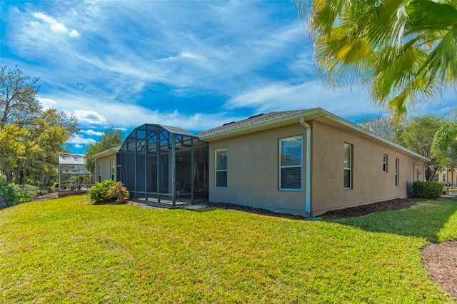 back of property featuring a lawn and glass enclosure