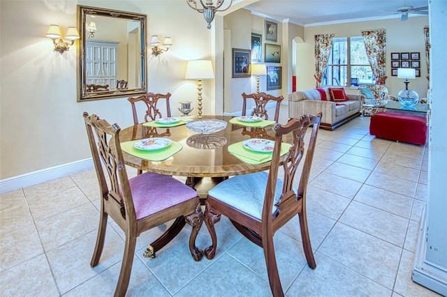 tiled dining room featuring ceiling fan and crown molding