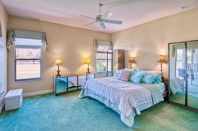 carpeted bedroom featuring multiple windows, a textured ceiling, and ceiling fan