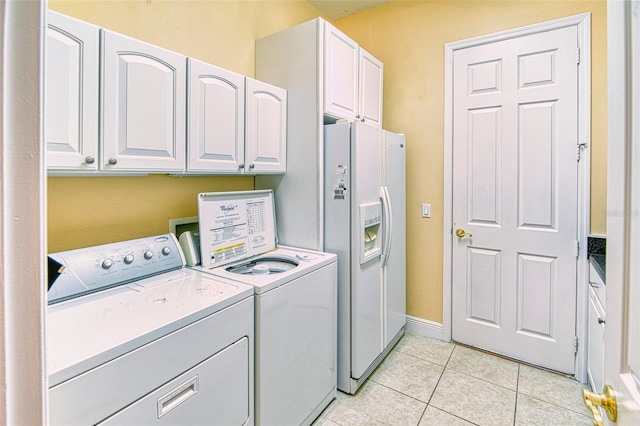 clothes washing area with light tile floors, washing machine and dryer, cabinets, and hookup for a washing machine