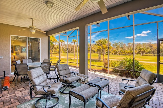 sunroom with ceiling fan, a wealth of natural light, and wood ceiling