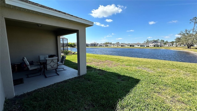 view of yard featuring a water view and a patio area