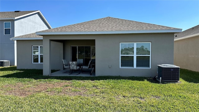 rear view of property with central AC unit, a lawn, and a patio