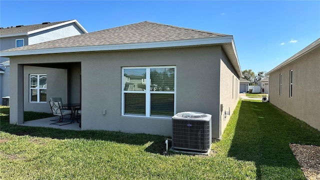 rear view of house with a lawn, a patio, and central AC unit