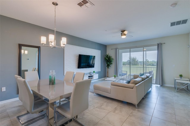 tiled dining area with ceiling fan with notable chandelier