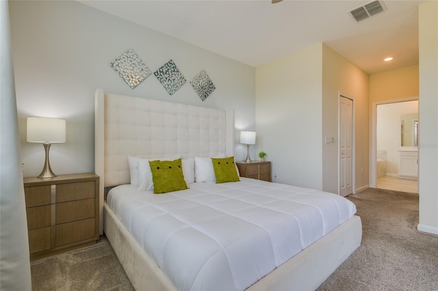 carpeted bedroom featuring a closet and connected bathroom