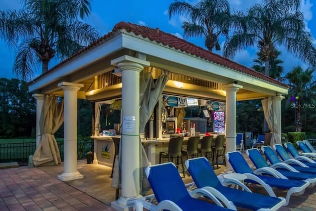 patio terrace at dusk with a gazebo and an outdoor bar