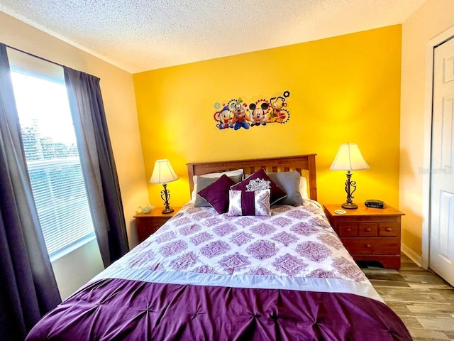 bedroom featuring light hardwood / wood-style flooring and a textured ceiling