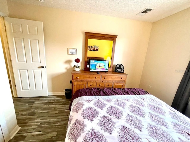 bedroom with dark hardwood / wood-style flooring and a textured ceiling