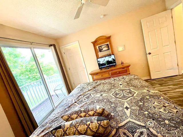 bedroom featuring ceiling fan, wood-type flooring, a textured ceiling, and access to outside