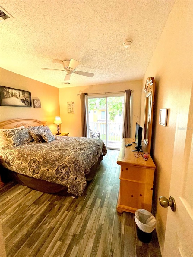 bedroom featuring a textured ceiling, ceiling fan, access to exterior, and dark wood-type flooring