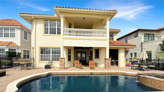 rear view of house with a patio, a balcony, and a fenced in pool