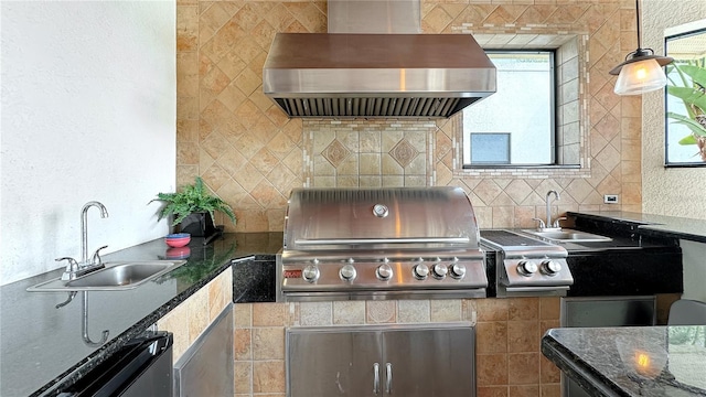 kitchen featuring sink, dark stone counters, and wall chimney exhaust hood