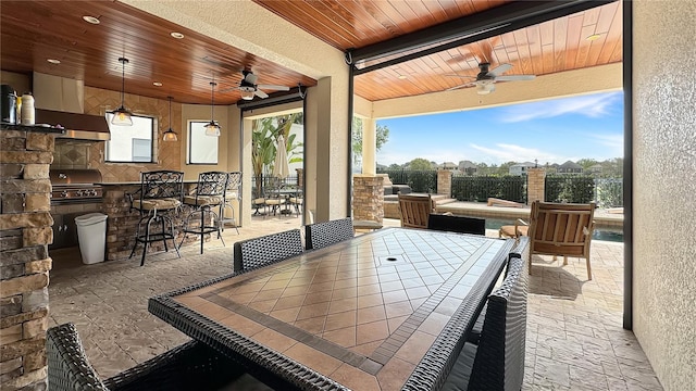 view of patio with ceiling fan, an outdoor kitchen, and area for grilling