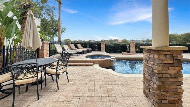 view of swimming pool featuring an in ground hot tub and a patio