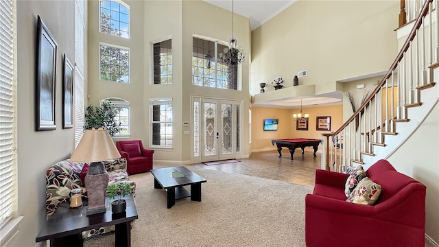 tiled living room featuring a towering ceiling, a notable chandelier, pool table, and french doors