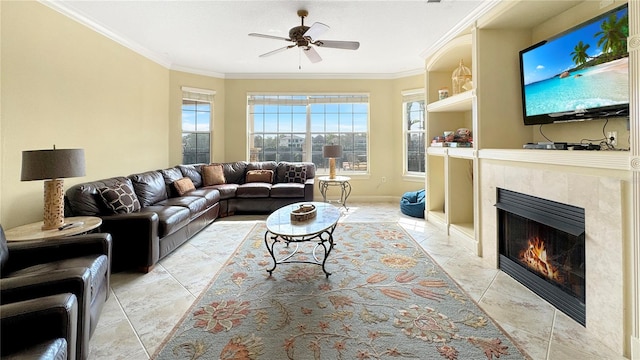 tiled living room with crown molding, ceiling fan, and a fireplace