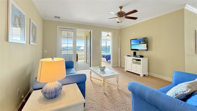 carpeted living room featuring ceiling fan, ornamental molding, and a healthy amount of sunlight