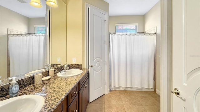 bathroom with dual bowl vanity, an inviting chandelier, and tile flooring