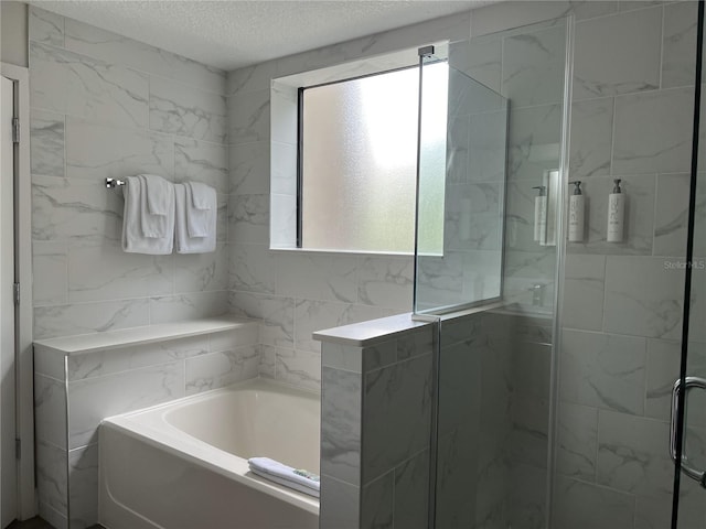 bathroom with separate shower and tub and a textured ceiling