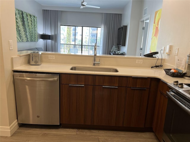 kitchen with stainless steel appliances, dark brown cabinets, sink, and light hardwood / wood-style floors