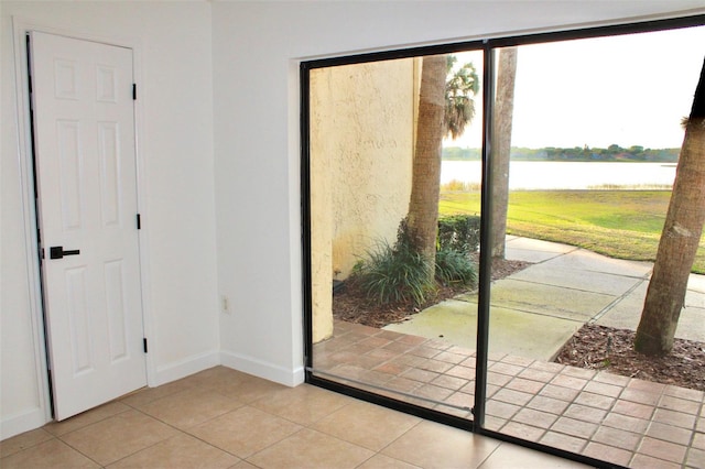 doorway with light tile flooring and a water view