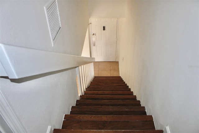 stairway featuring dark tile floors