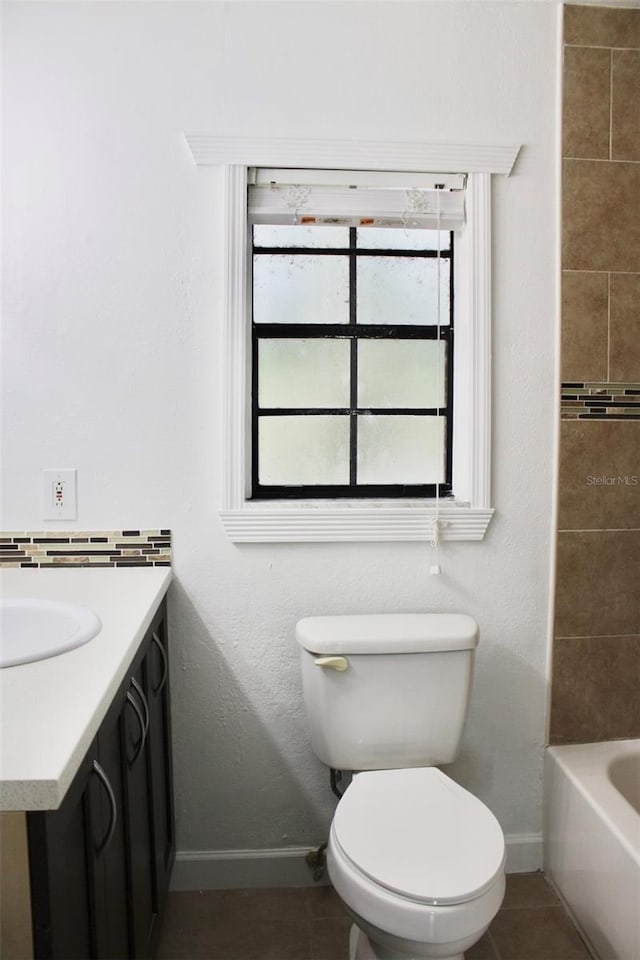 full bathroom featuring vanity, tile floors, toilet, and a healthy amount of sunlight