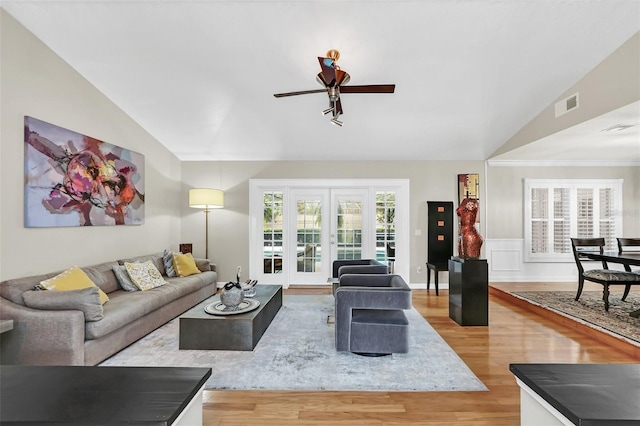 living room featuring french doors, light hardwood / wood-style floors, ceiling fan, and vaulted ceiling