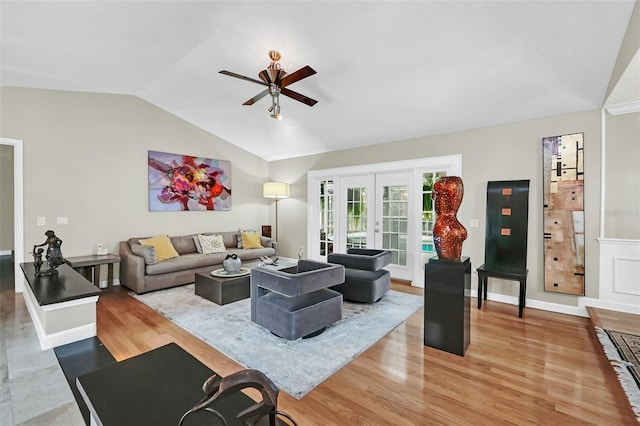 living room featuring lofted ceiling, light hardwood / wood-style floors, ceiling fan, and french doors