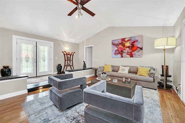 living room with french doors, light hardwood / wood-style floors, ceiling fan, and lofted ceiling