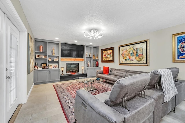 living room featuring light tile floors, a notable chandelier, a textured ceiling, and built in features