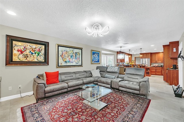 tiled living room featuring a notable chandelier and a textured ceiling