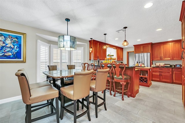 dining area featuring light tile floors and a textured ceiling