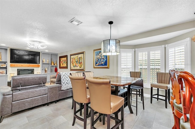 tiled dining area featuring built in features and a textured ceiling