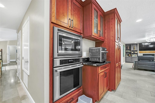 kitchen featuring a textured ceiling, light tile floors, and appliances with stainless steel finishes