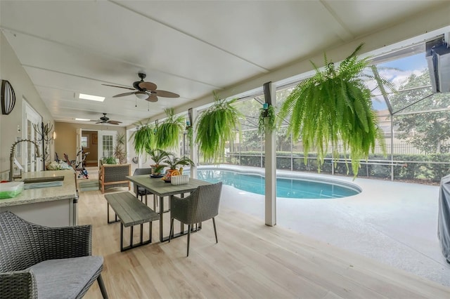 exterior space with a patio area, ceiling fan, glass enclosure, and sink