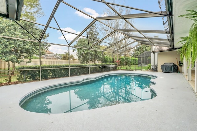 view of pool with a patio area, area for grilling, and glass enclosure