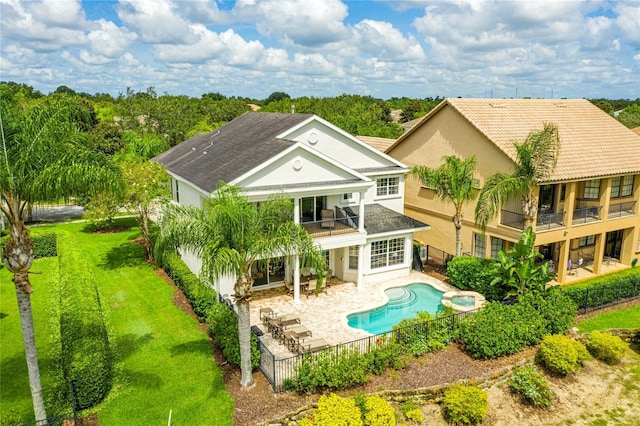 back of house with a patio area, a lawn, and a balcony