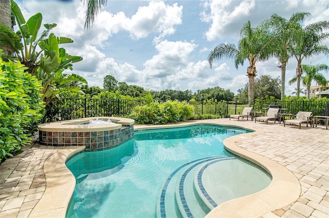 view of swimming pool with a patio area and an in ground hot tub