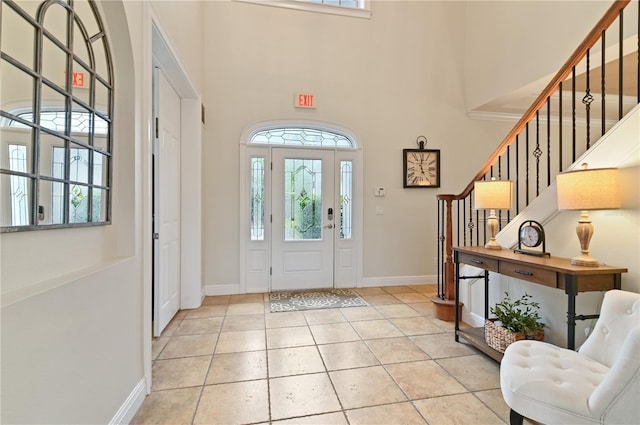 foyer featuring light tile patterned floors and a high ceiling