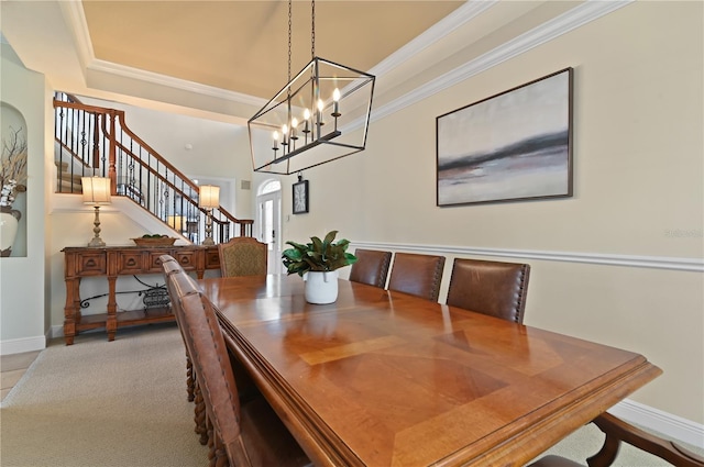 carpeted dining room with crown molding and a chandelier