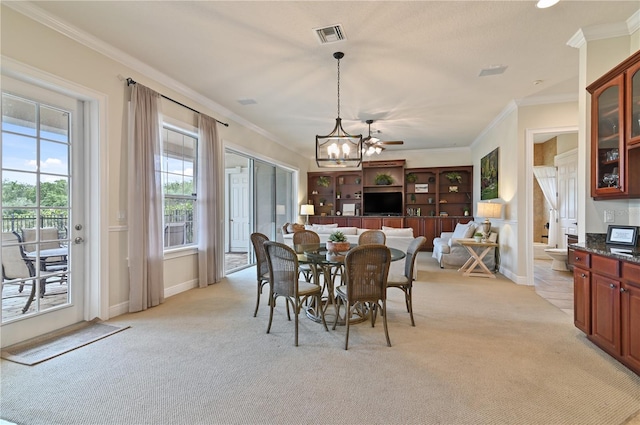 dining room featuring ceiling fan, ornamental molding, and light carpet