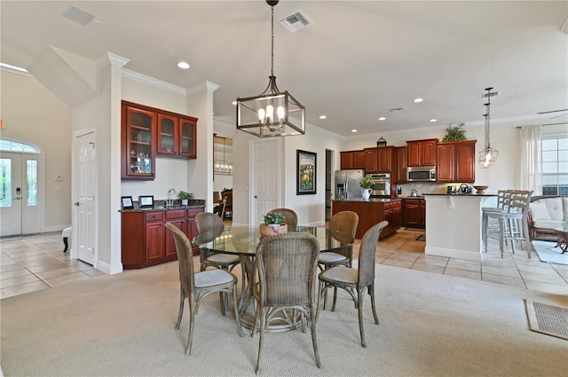 tiled dining room with ornamental molding, ceiling fan with notable chandelier, and sink